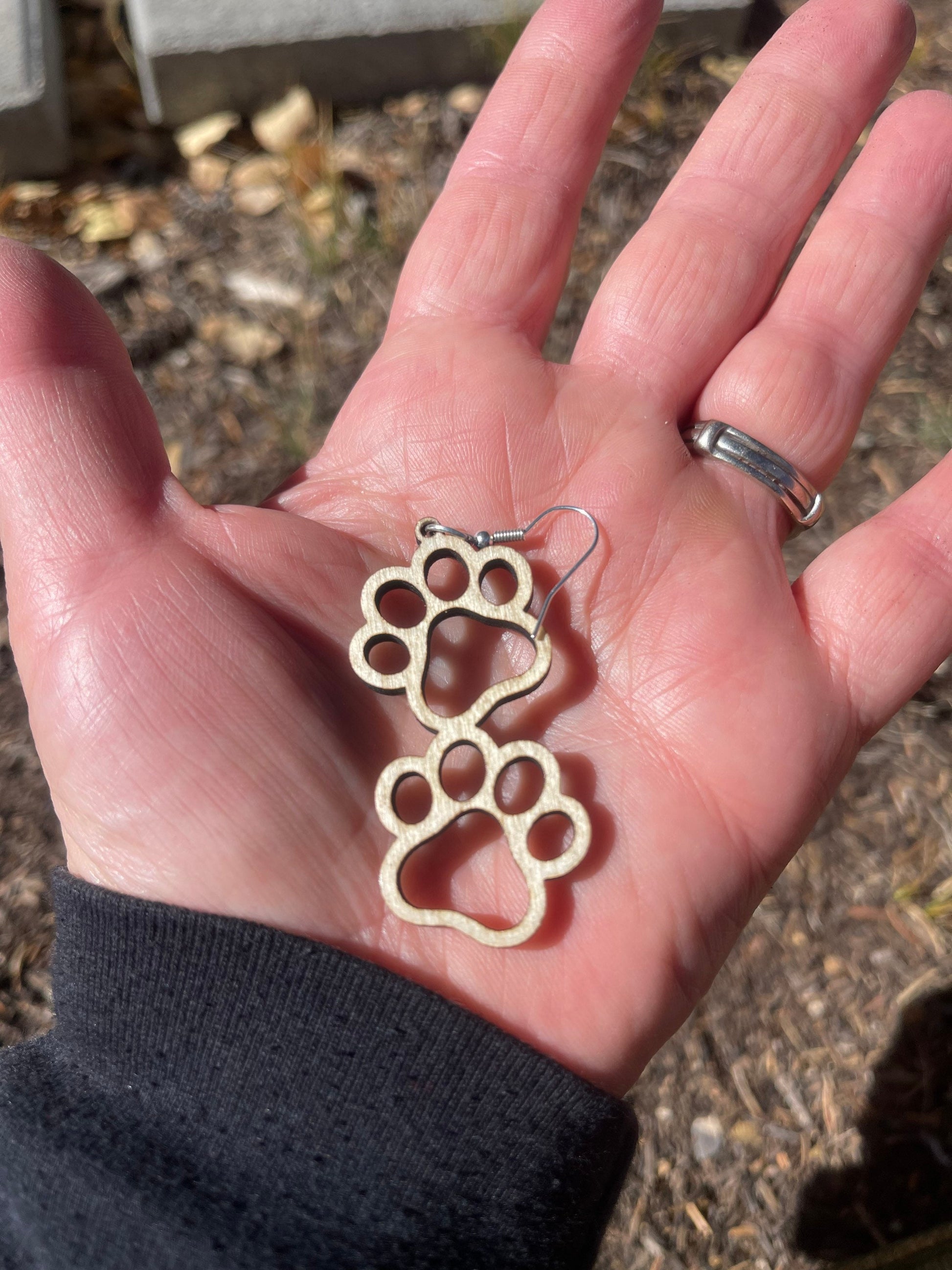 Double paw print dangle earrings to show the love for your favorite dog or cat. They are laser cut, lightweight birchwood that can be worn easily all day. 

Wood is a natural material. There will be color, texture and grain variations may occur.