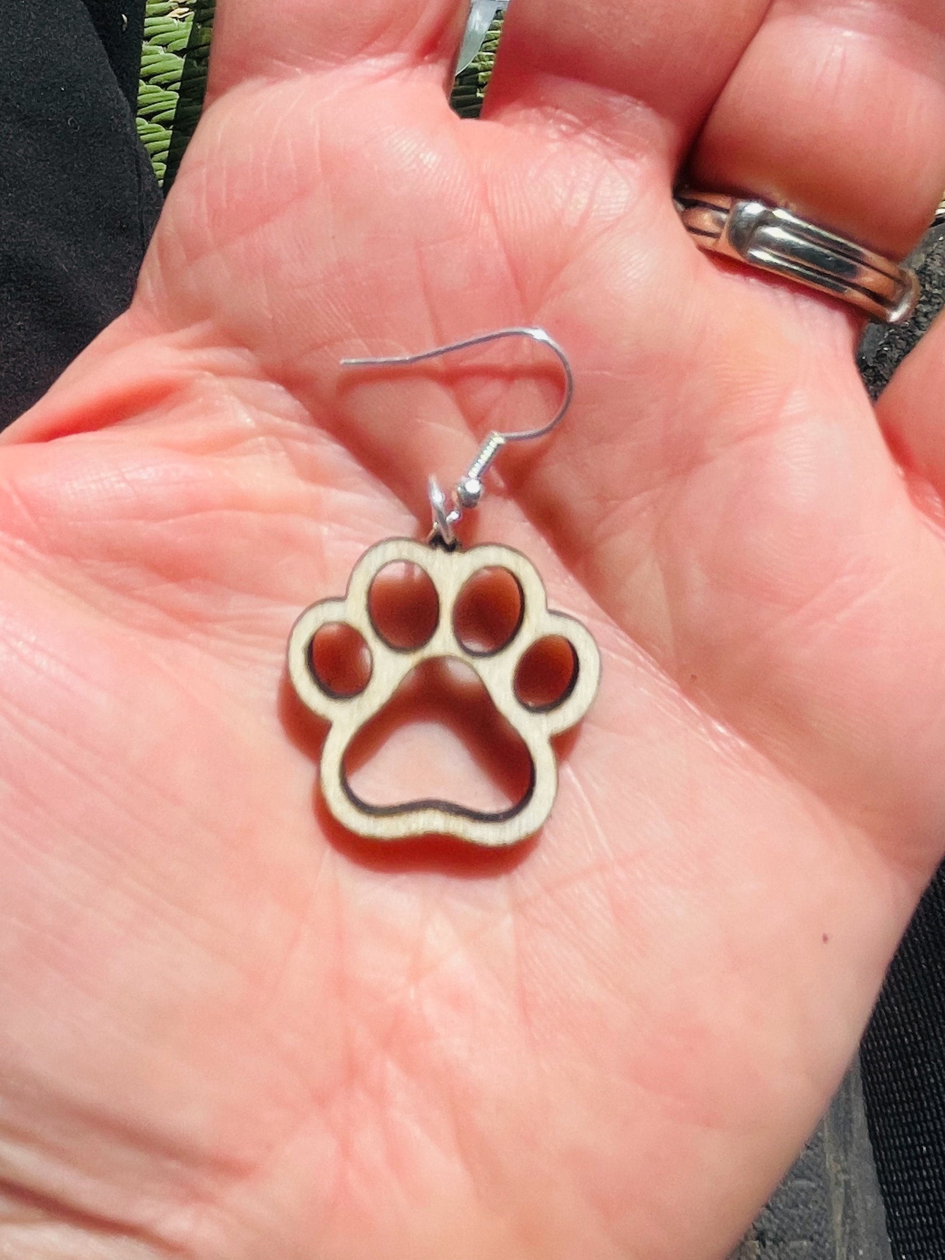 Single paw print dangle earrings to show the love for your favorite dog or cat. They are laser cut, lightweight birchwood dangle earring that can be worn easily all day. Great gift for mom or any pet lover.