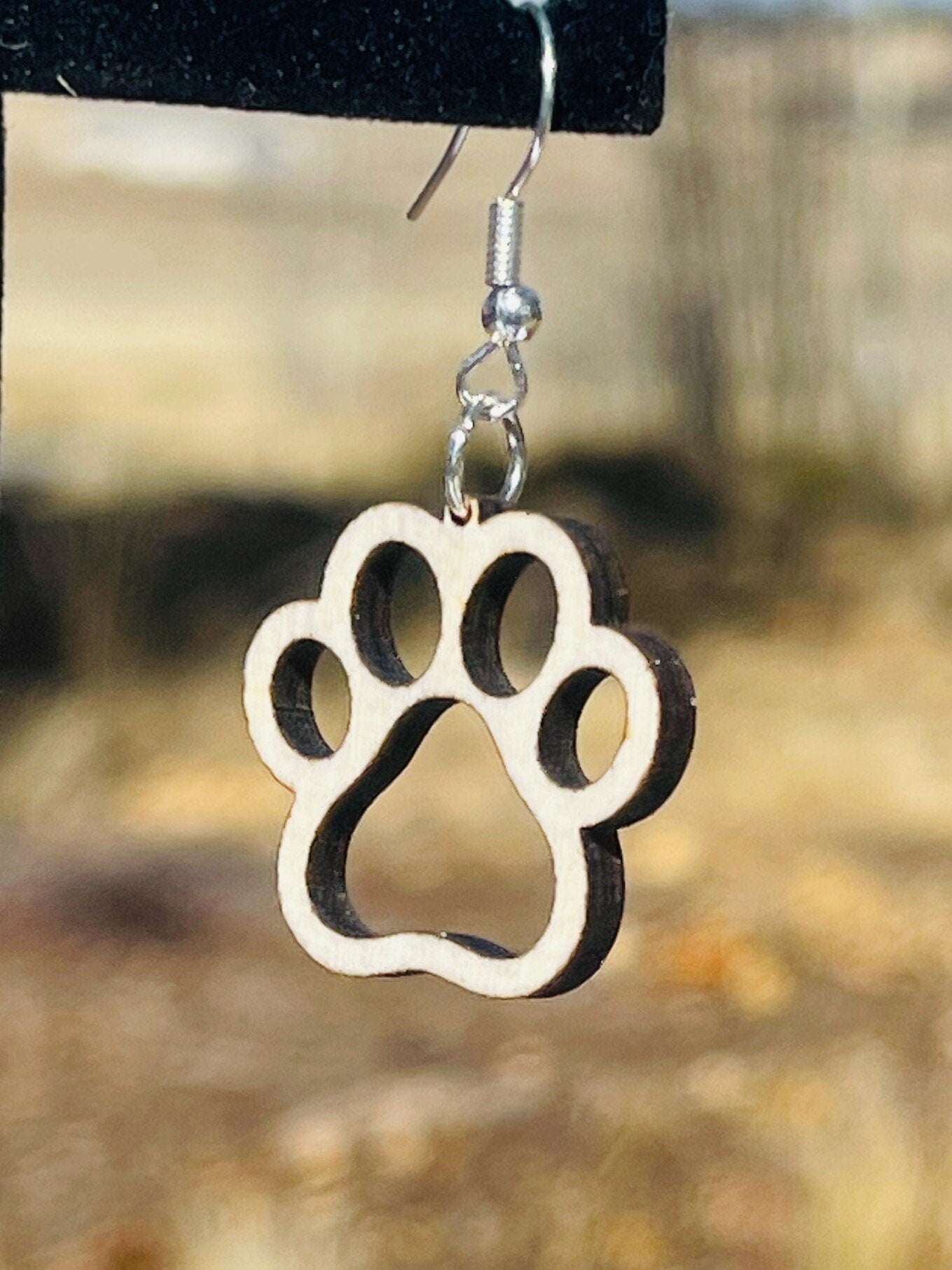 Single paw print dangle earrings to show the love for your favorite dog or cat. They are laser cut, lightweight birchwood dangle earring that can be worn easily all day. Great gift for mom or any pet lover.