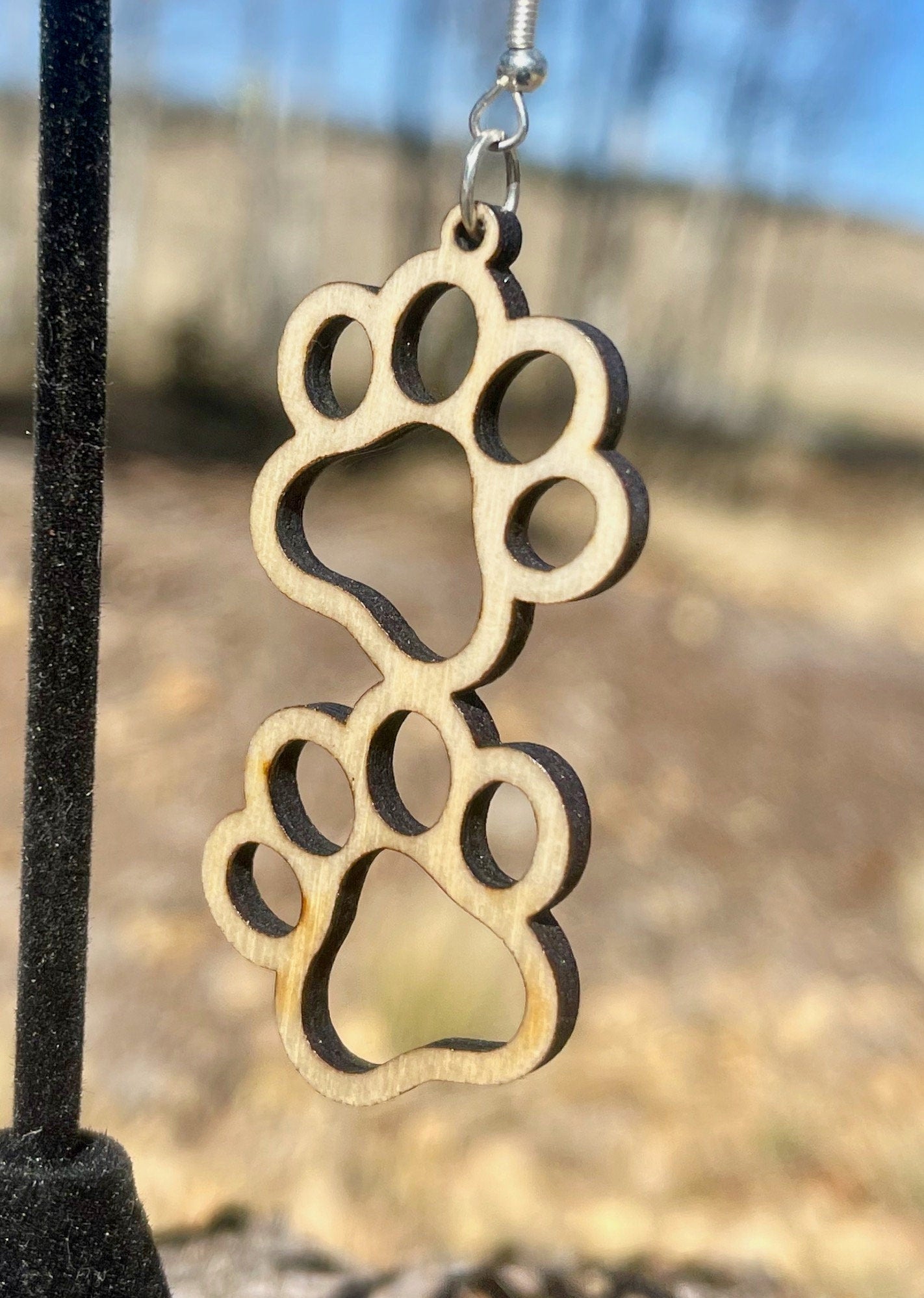 Double paw print dangle earrings to show the love for your favorite dog or cat. They are laser cut, lightweight birchwood that can be worn easily all day. 

Wood is a natural material. There will be color, texture and grain variations may occur.