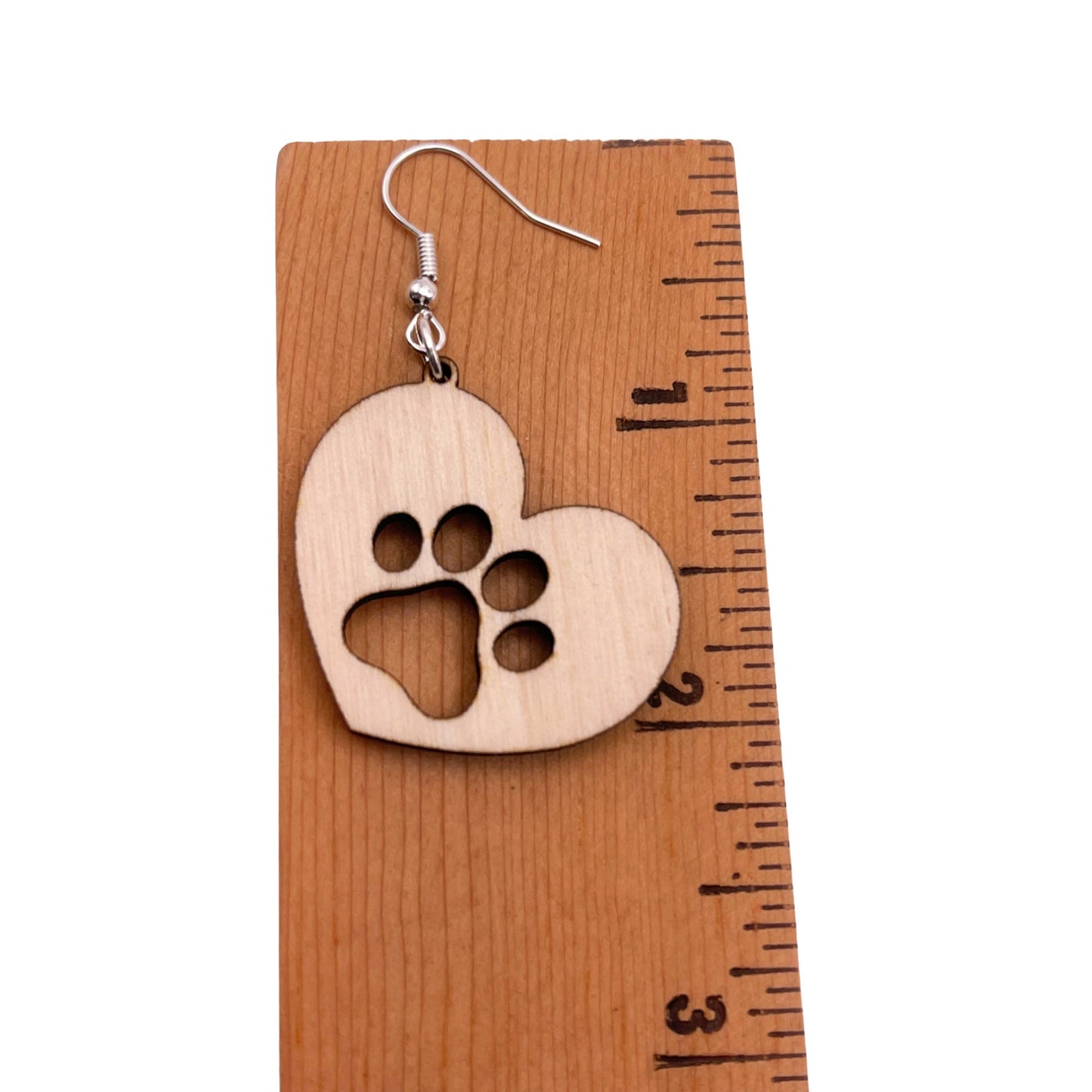 Solid heart dangle earring with a single paw print, approximately 2 inches, hanging from the top side of the heart. They are laser cut, lightweight birchwood dangle earring that can be worn easily all day. Great gift for mom or any pet lover.