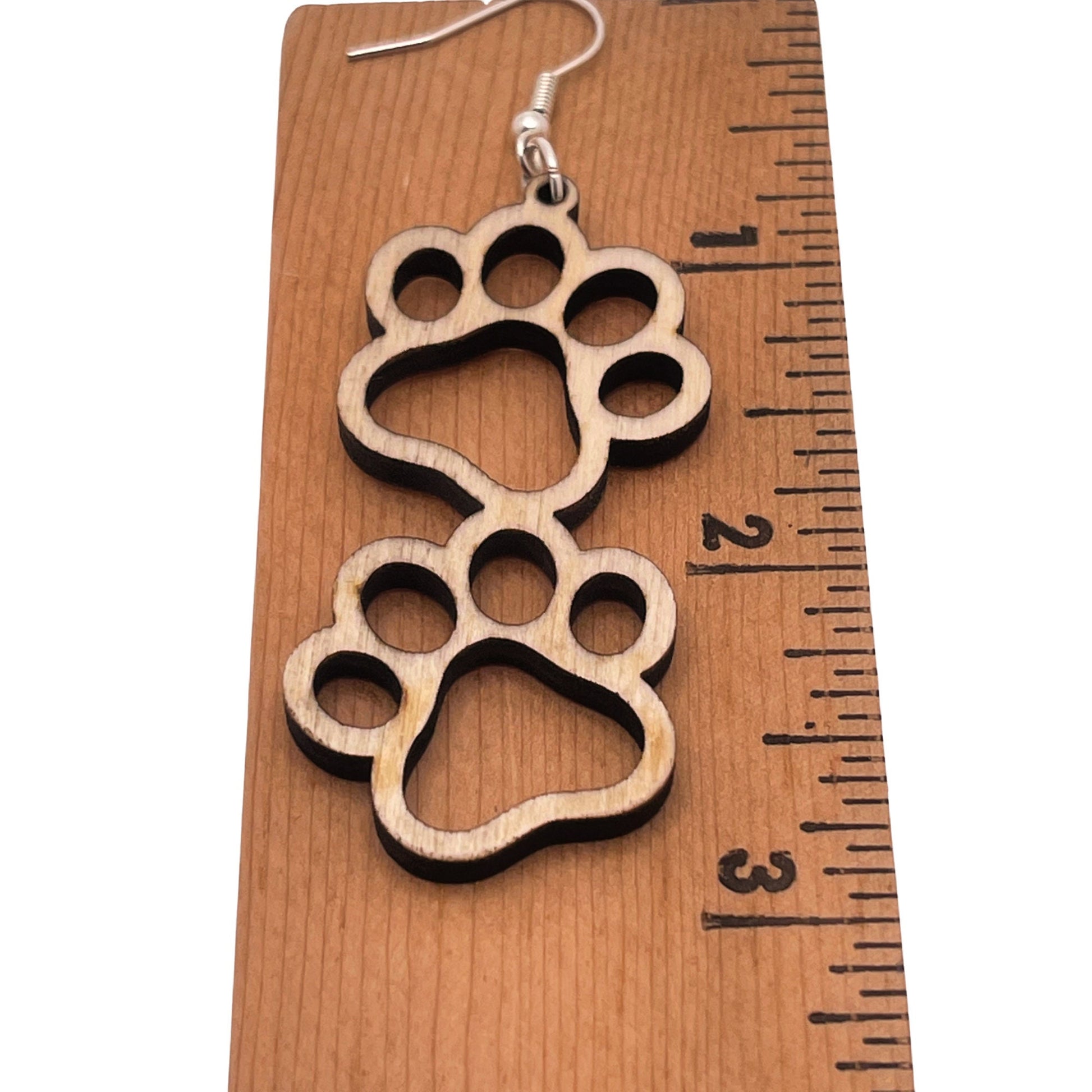 Double paw print dangle earrings, approximately 3in long, to show the love for your favorite dog or cat. They are laser cut, lightweight birchwood that can be worn easily all day.
