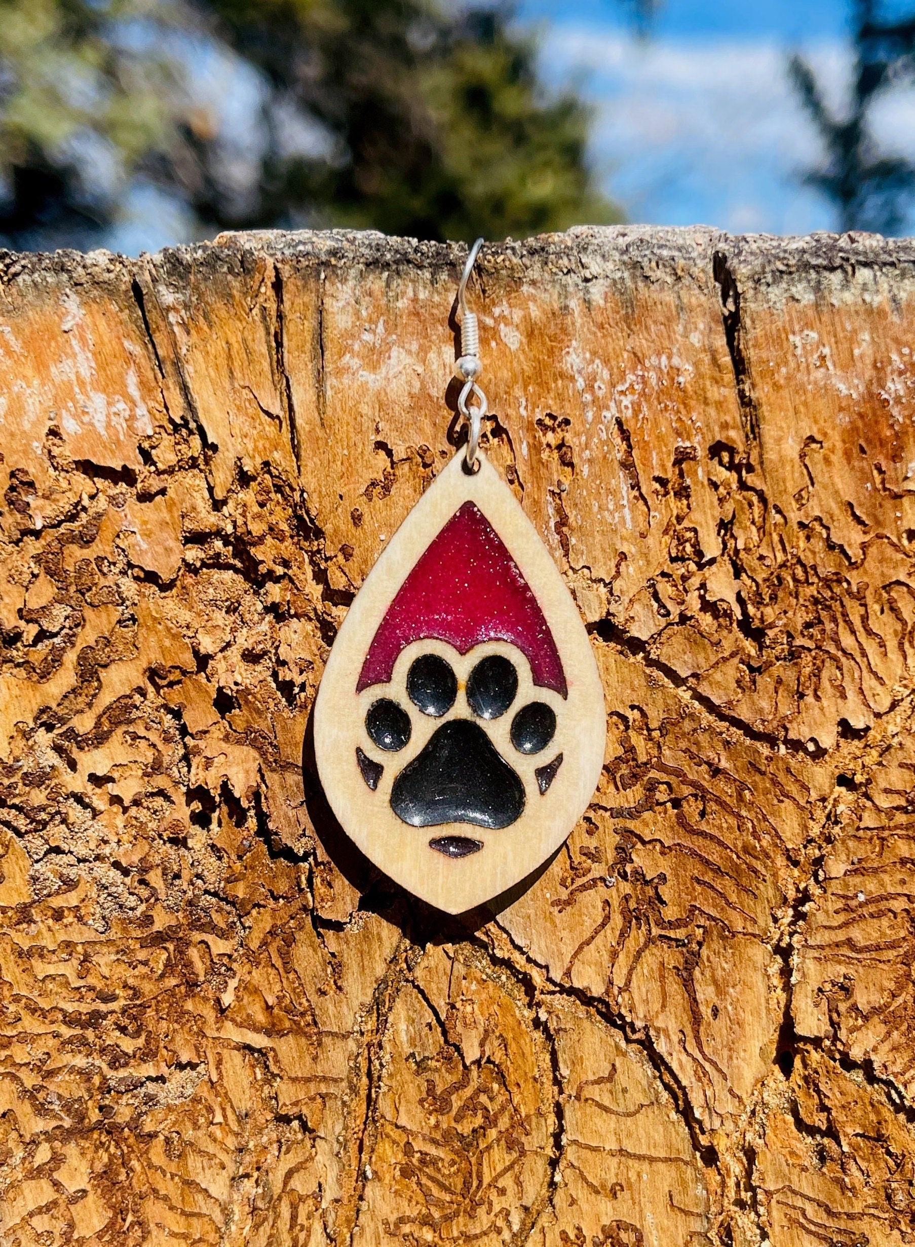 Tear drop dangle earring with a single paw print with pink and black resin, approximately 2.5 inches. They are laser cut, lightweight birchwood dangle earring that can be worn easily all day. Great gift for mom or any pet lover.