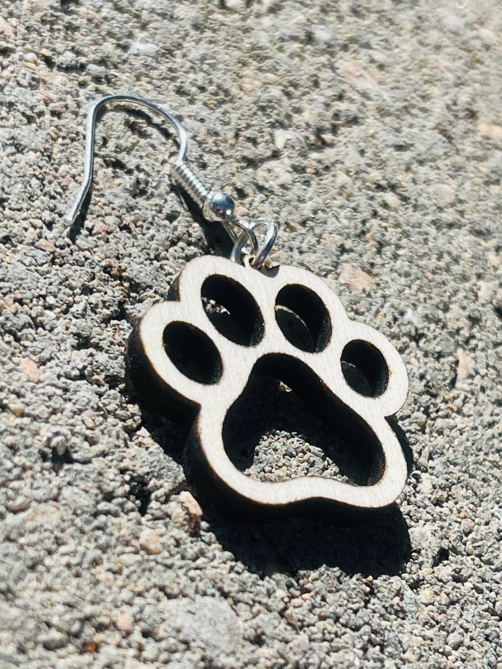 Single paw print dangle earrings to show the love for your favorite dog or cat. They are laser cut, lightweight birchwood dangle earring that can be worn easily all day. Great gift for mom or any pet lover.