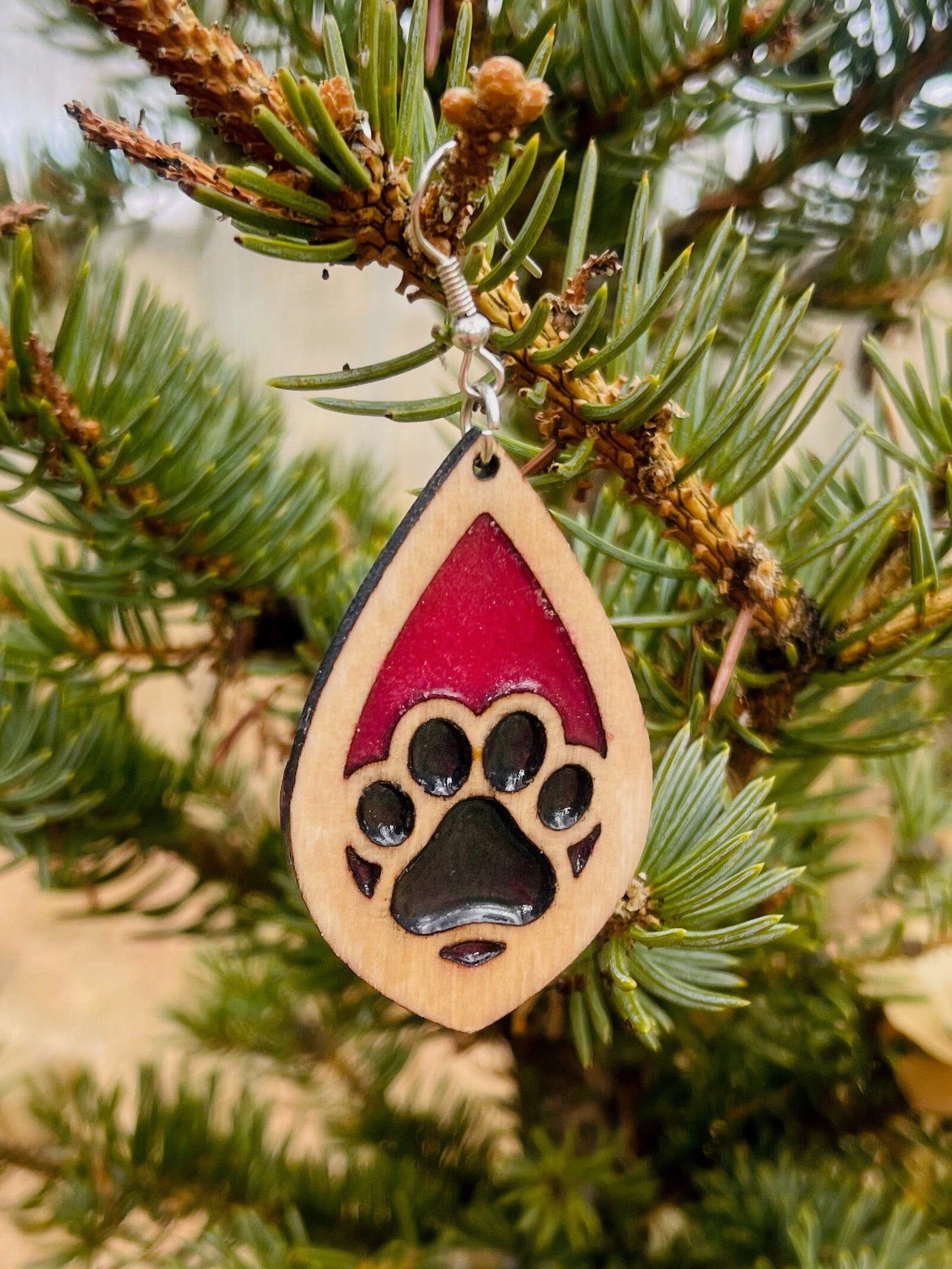 Tear drop dangle earring with a single paw print with pink and black resin, approximately 2.5 inches. They are laser cut, lightweight birchwood dangle earring that can be worn easily all day. Great gift for mom or any pet lover.
