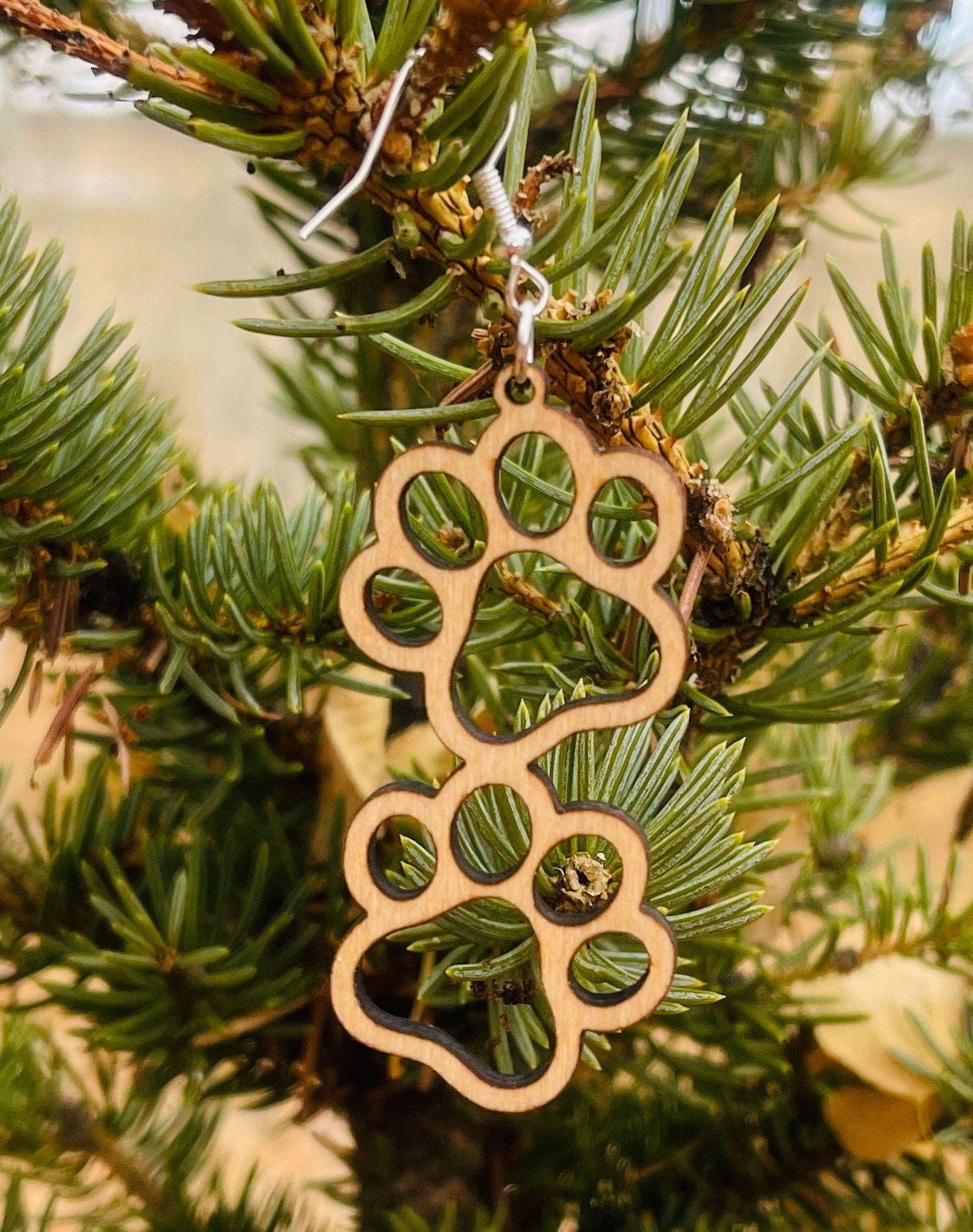 Double paw print dangle earrings to show the love for your favorite dog or cat. They are laser cut, lightweight birchwood that can be worn easily all day. 

Wood is a natural material. There will be color, texture and grain variations may occur.
