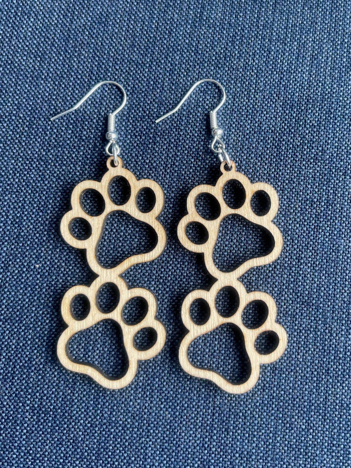 Double paw print dangle earrings to show the love for your favorite dog or cat. They are laser cut, lightweight birchwood that can be worn easily all day. 

Wood is a natural material. There will be color, texture and grain variations may occur.