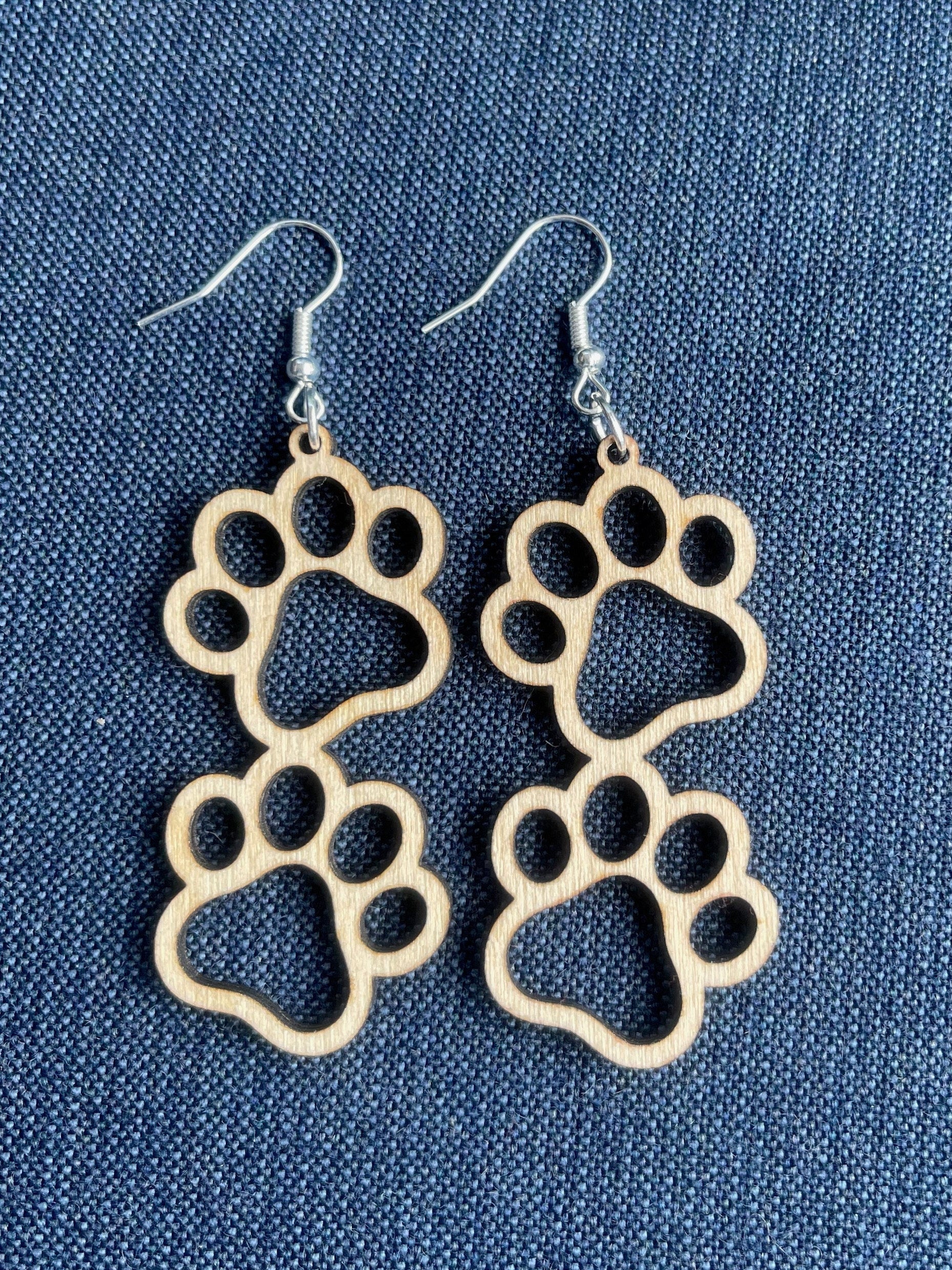 Double paw print dangle earrings to show the love for your favorite dog or cat. They are laser cut, lightweight birchwood that can be worn easily all day. 

Wood is a natural material. There will be color, texture and grain variations may occur.